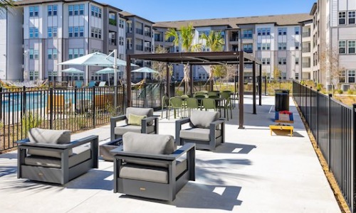 Outdoor lounge and patio area with fire pit and games at luxury apartments in Kissimmee, FL.