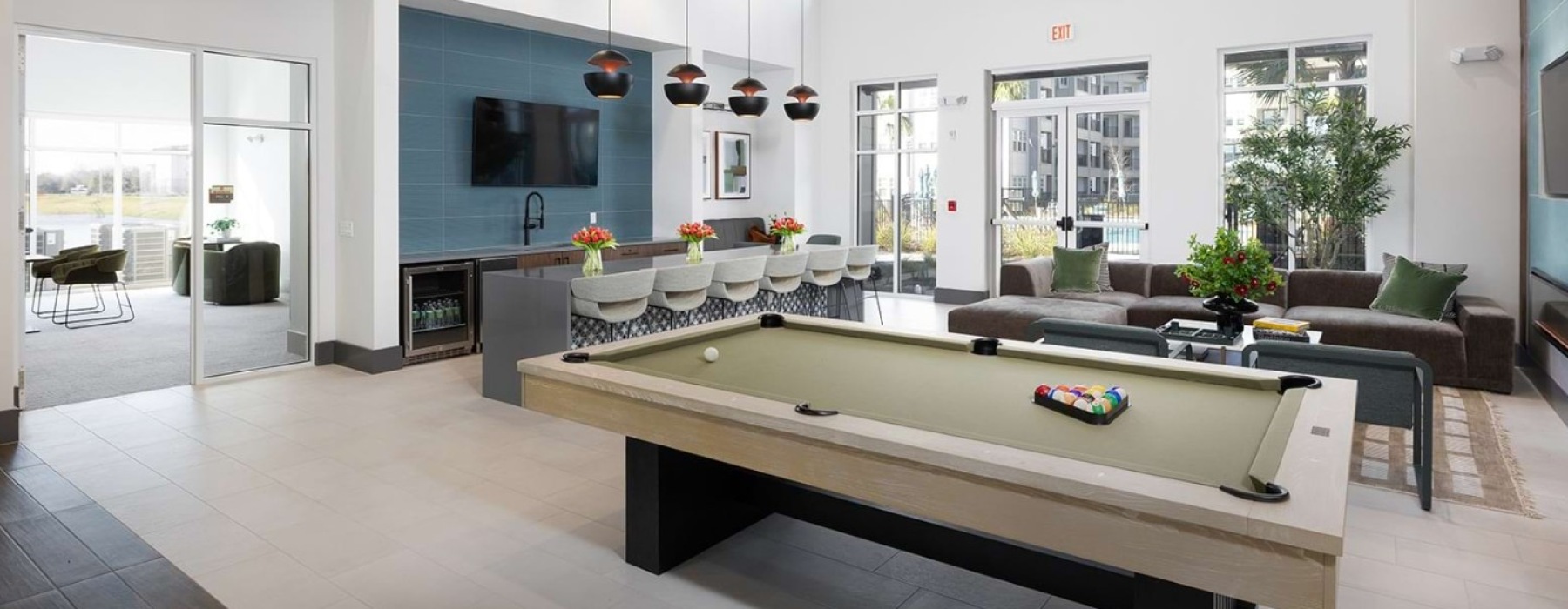 Solaris Apartments clubhouse with billiards table, lounge seating, and bar area