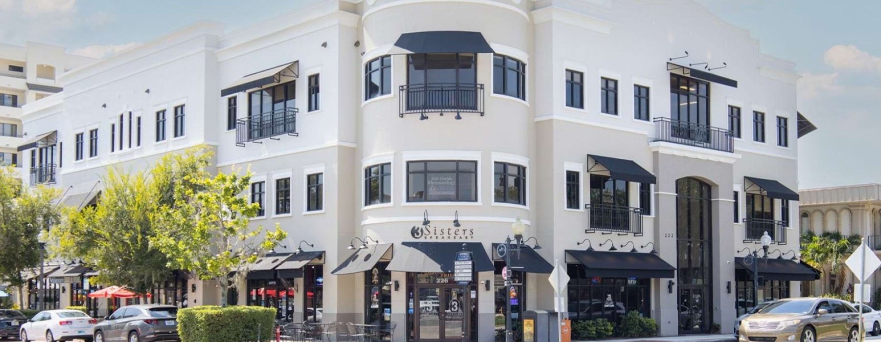 Exterior view of a modern retail and commercial building on a corner in the thriving Historic Downtown Kissimmee area, featuring local restaurants and shops.