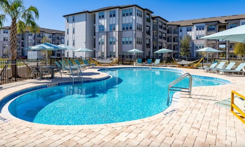 Resort-style swimming pool and sun deck at Solaris at Kissimmee apartments in Kissimmee, FL.