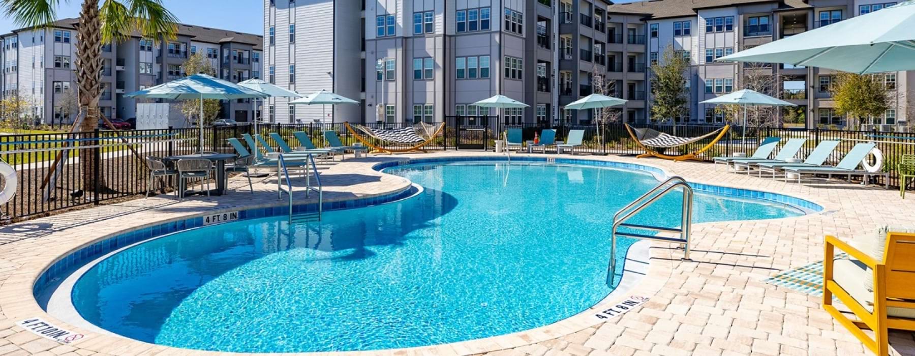 Resort-style swimming pool and sun deck at Solaris at Kissimmee apartments in Kissimmee, FL.