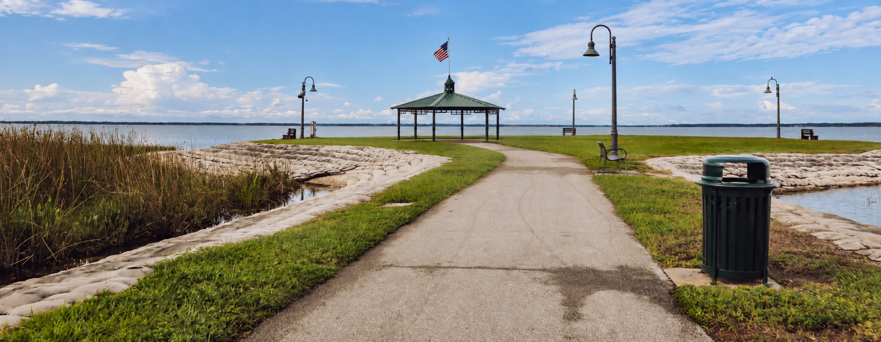Paved path to lakefront gazebo with American flag in St. Cloud Florida