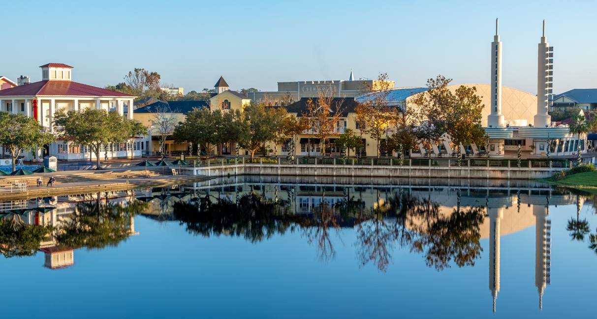 Celebration Florida downtown buildings and twin spires reflected in calm lake at sunrise