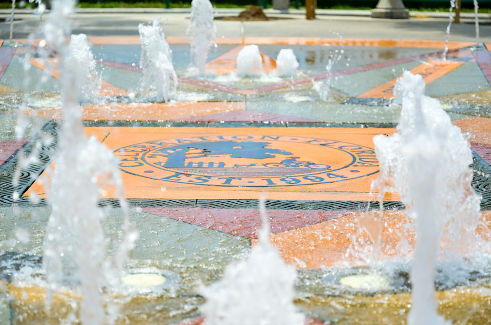 Splash fountain jets surrounding Celebration Florida Est 1994 town seal in colorful pavers