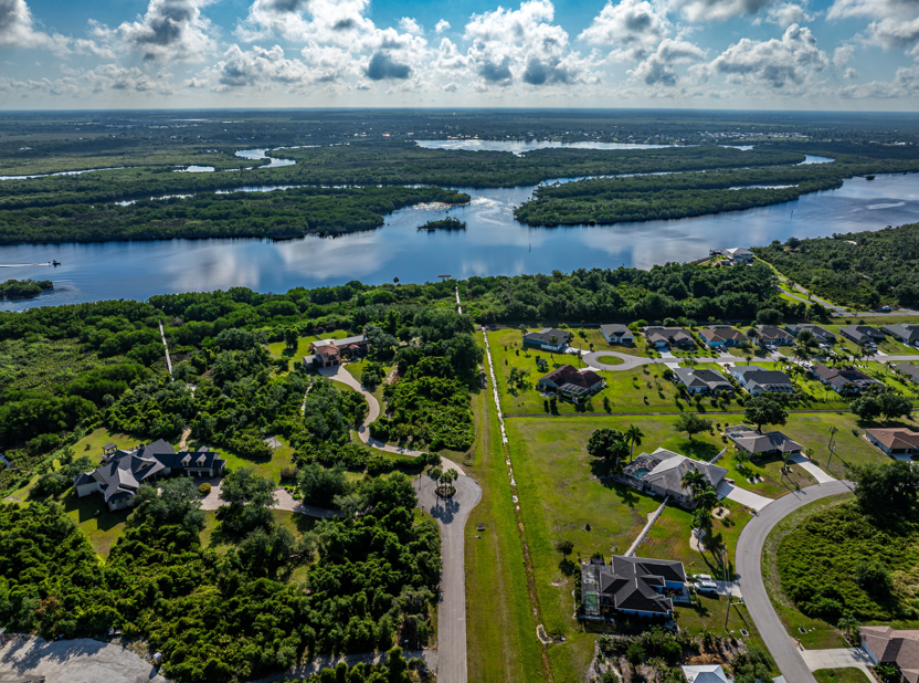 Aerial view of Florida homes and palm trees beside wide river and islands